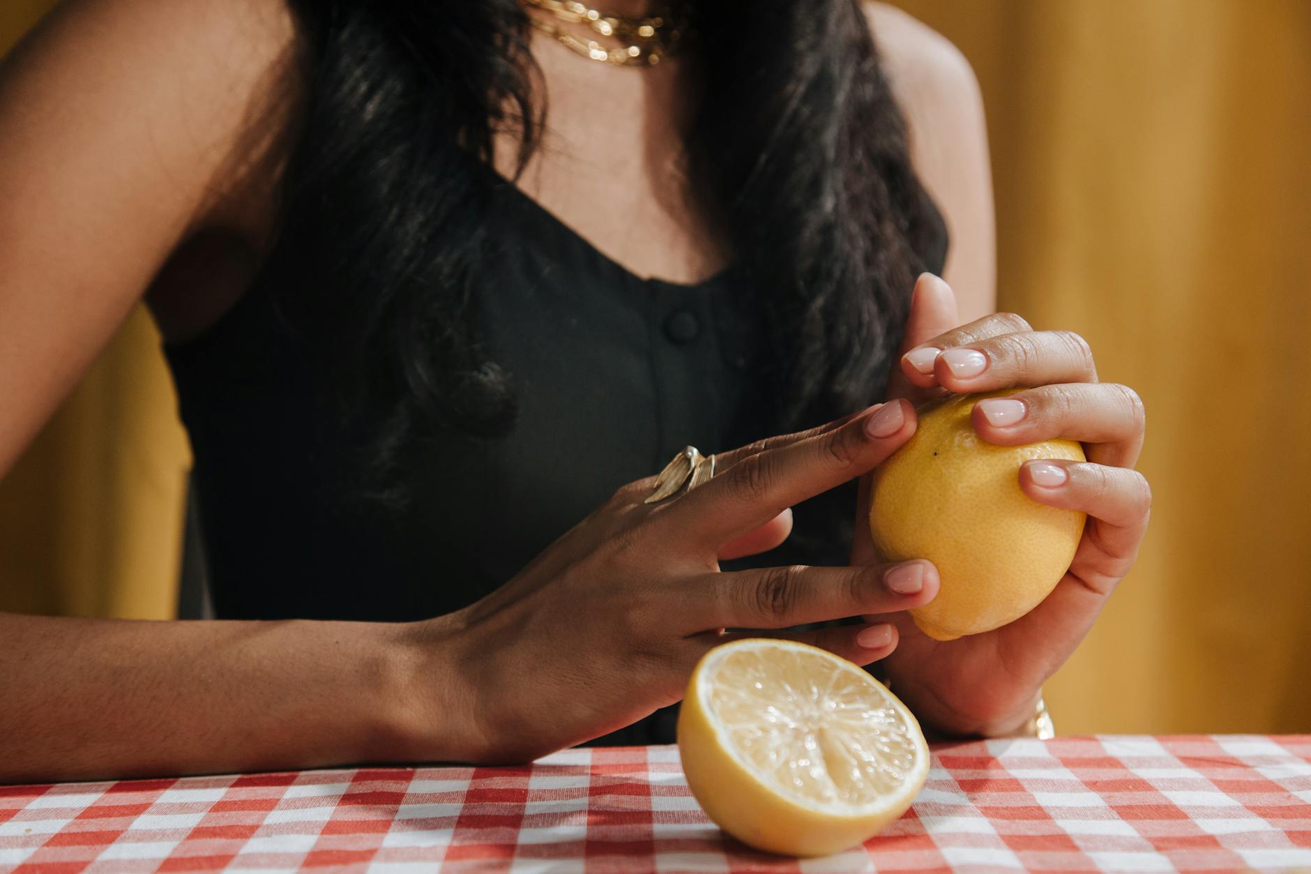 A hand holding an orange vibrator against a minimalistic purple backdrop, showcasing personal pleasure and self-care.